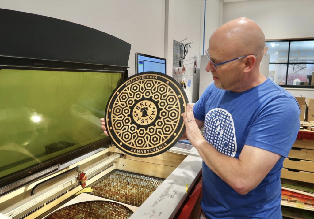 Artist using Trotec to engrave design on wood