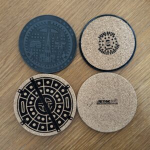 Handmade cork coasters featuring manhole cover artwork